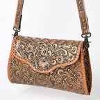 Metallic brown leather handbag with intricate floral patterns on a white background