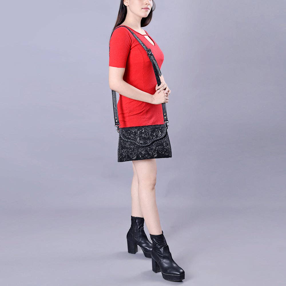Woman wearing a red top and black skirt with a black bag on a gray background
