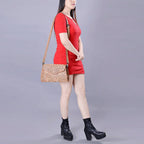 Woman in a red dress holding a patterned handbag on a gray background