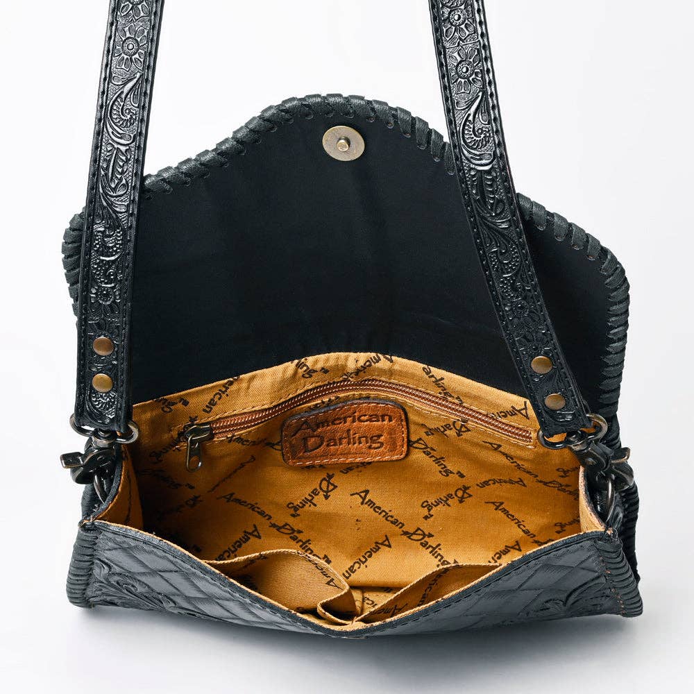 Black leather handbag with intricate designs on a white background