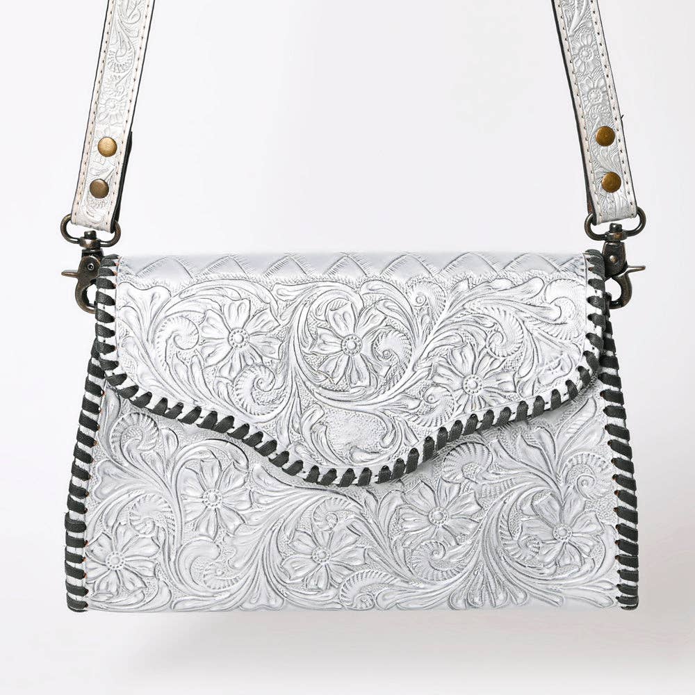 Metallic Silver leather handbag with intricate black tooled patterns on a white background