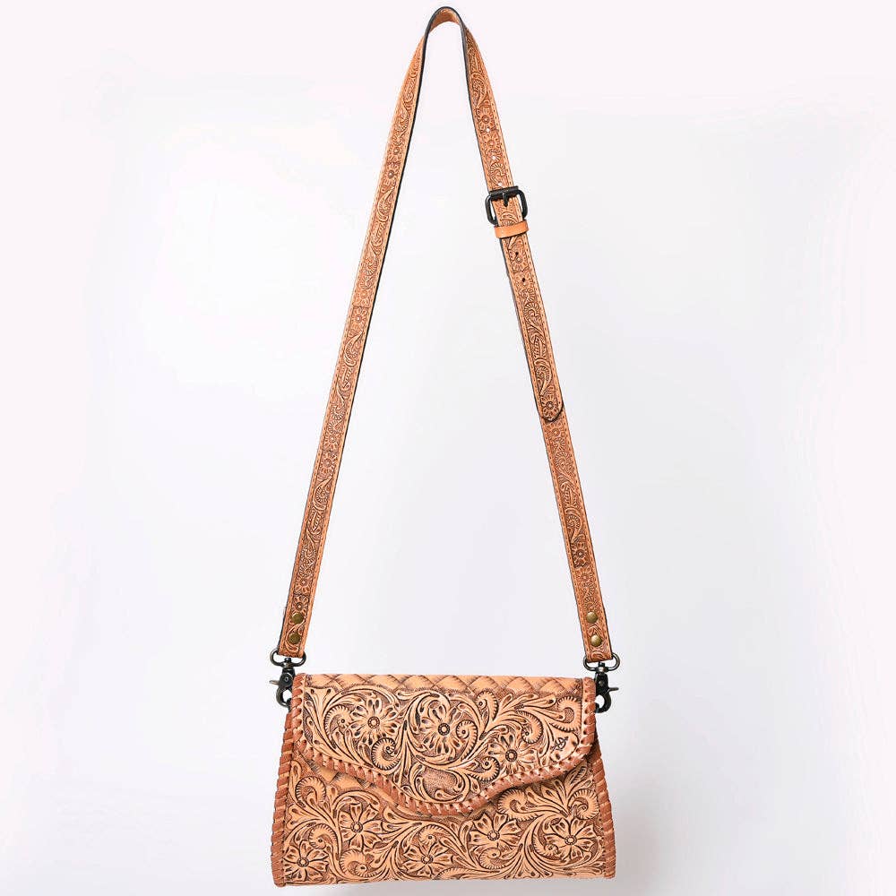 Brown leather crossbody bag with intricate patterns on a white background
