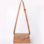 Brown leather crossbody bag with intricate patterns on a white background