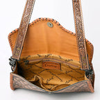 Brown leather handbag with intricate patterns and 'American Darling' branding on a white background