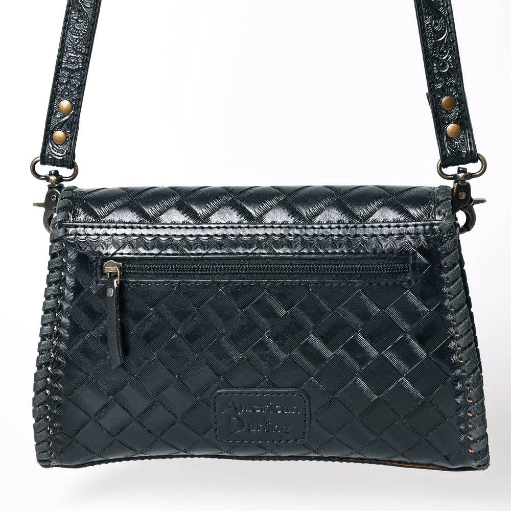 Black quilted handbag with gold accents on a white background