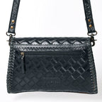 Black quilted handbag with gold accents on a white background
