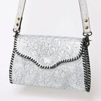 Metallic Silver leather handbag with intricate patterns on a white background