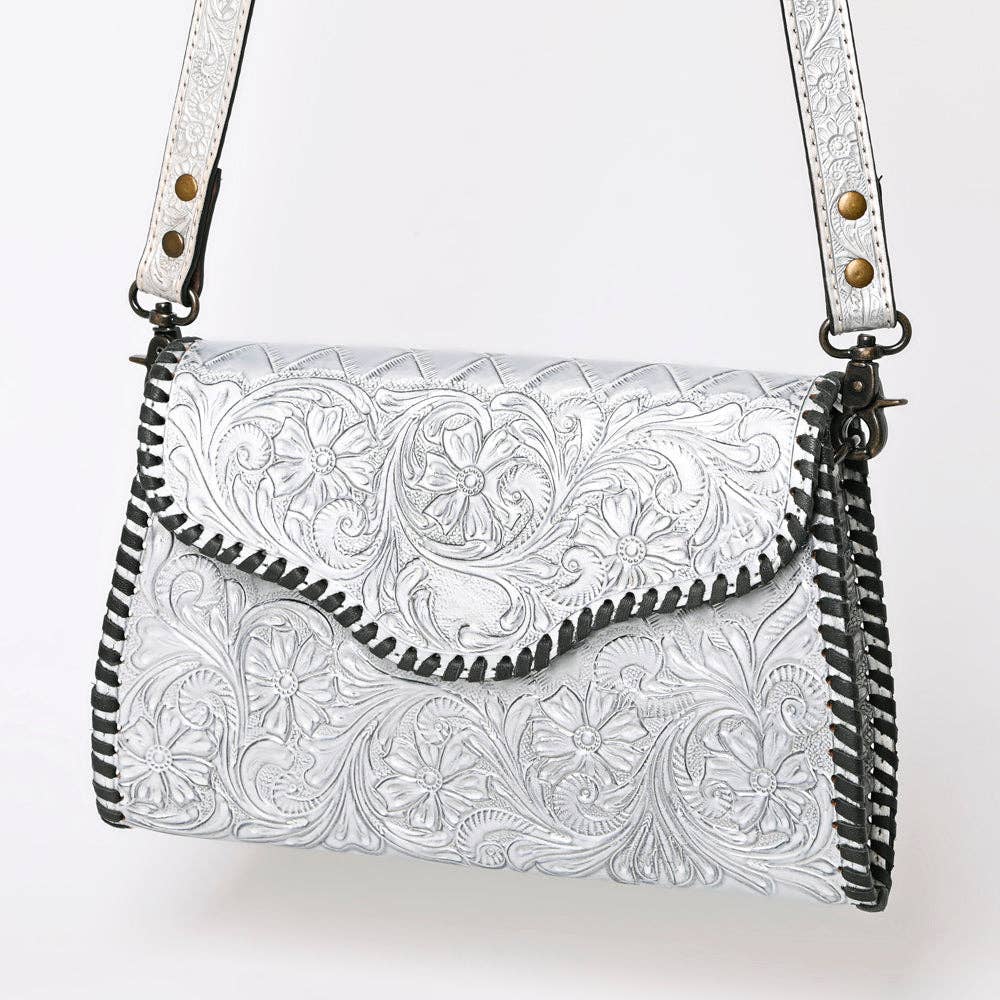 Metallic Silver leather handbag with intricate patterns on a white background