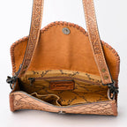 Brown leather handbag with intricate patterns on a white background