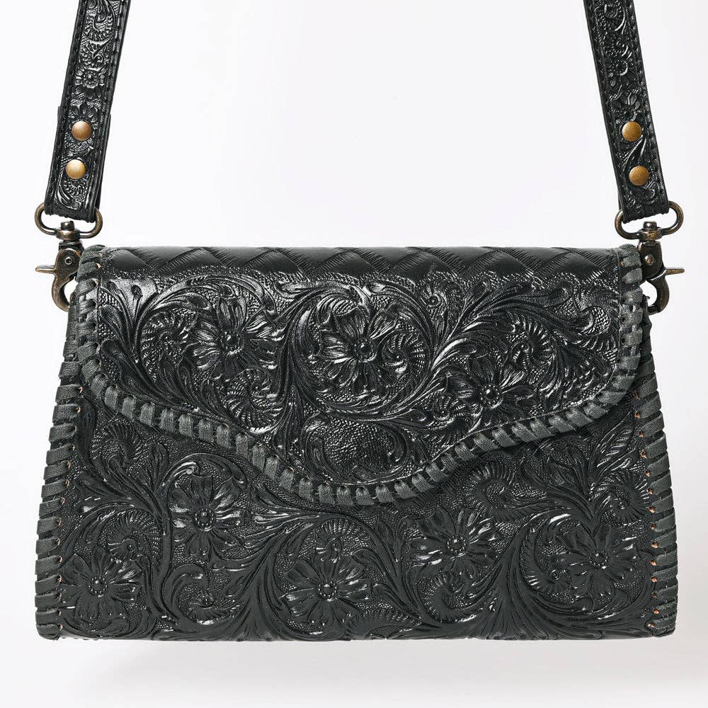 Black leather handbag with intricate floral tooled design on a white background